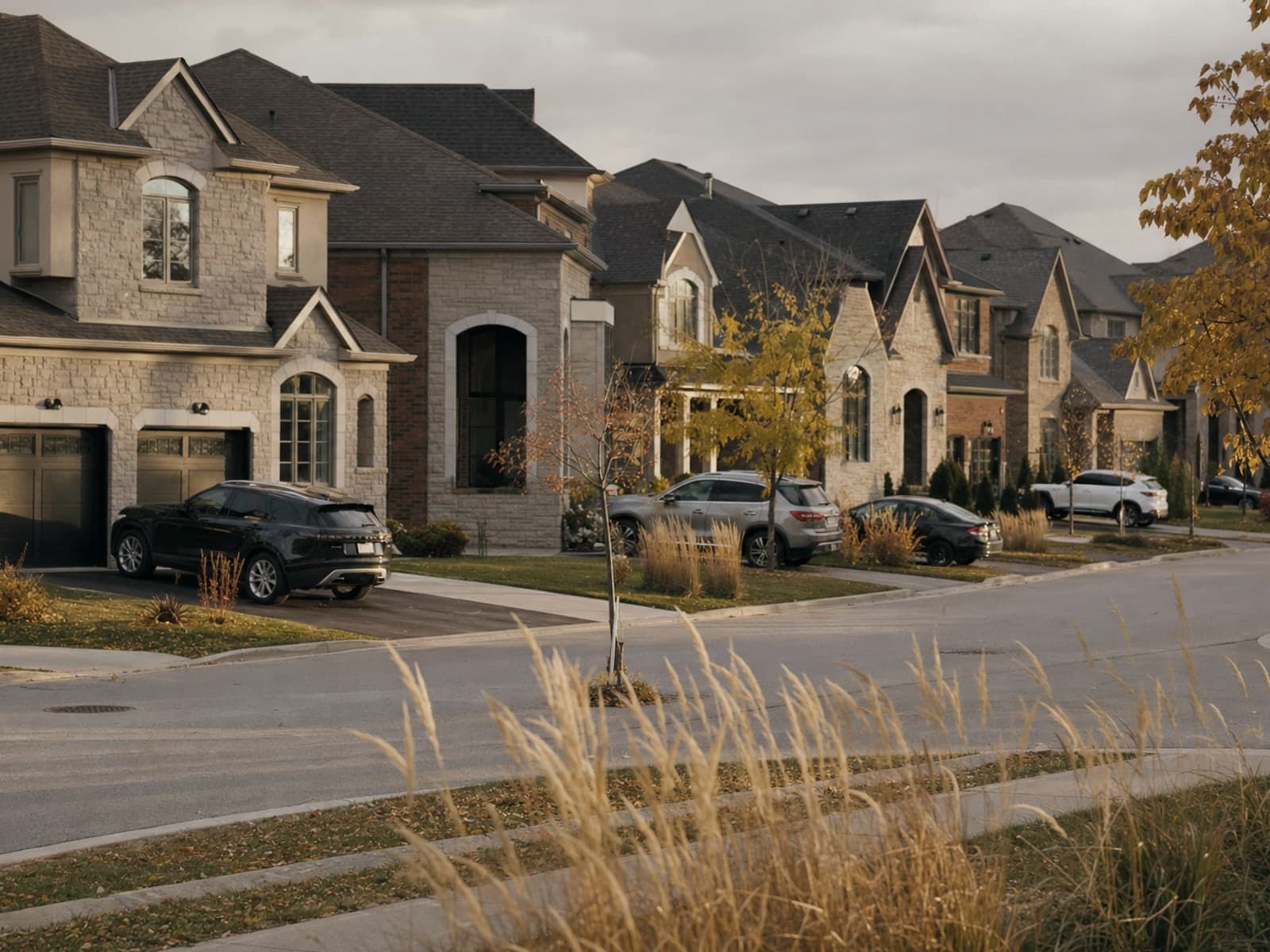 A wide suburban crescent of newer detached houses with double garages and long shadows