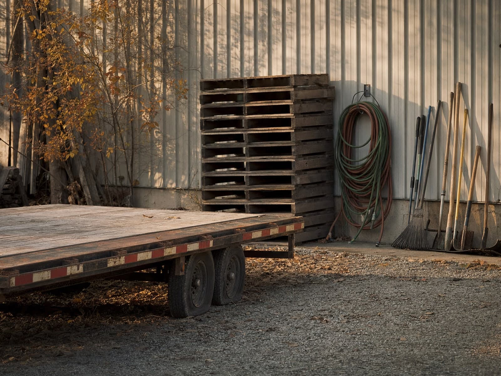 The yard behind a small family business at the end of the day, tools and pallets put away in order