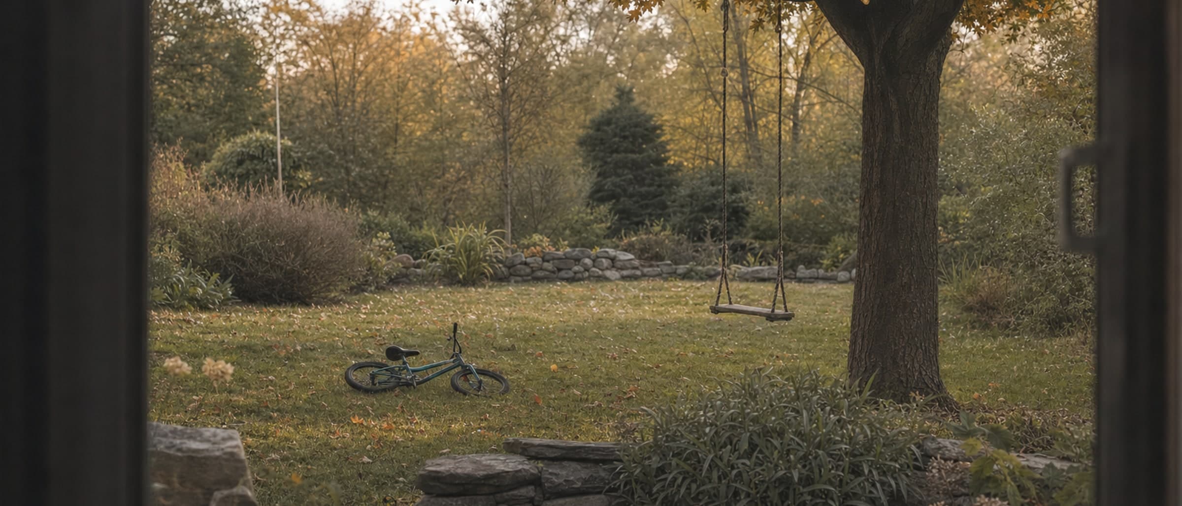 A back garden in autumn seen from a doorway, a rope swing on a maple